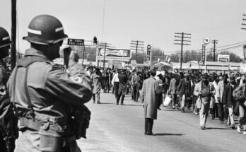 Los soldados están viendo caminar a los manifestantes de derechos civiles durante la tercera marcha de Selma en Alabama el 25 de marzo de 1965. El presidente Lyndon Johnson federalizó a la Guardia Nacional de Alabama para evitar la violencia contra los caminantes.
