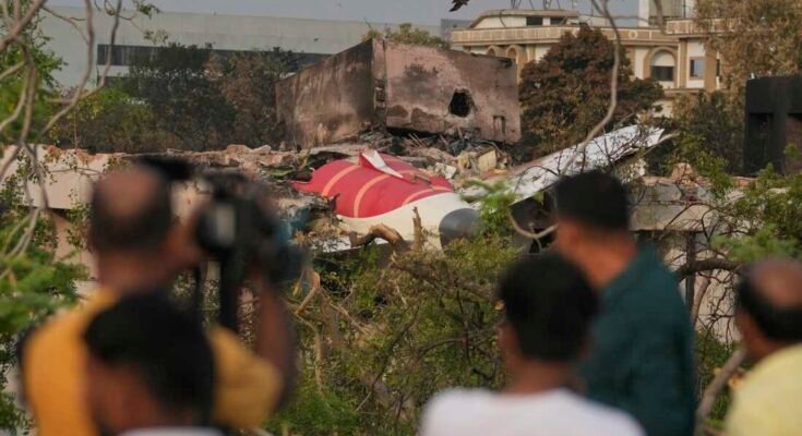 Los espectadores observan restos en el accidente de avión Air India el jueves en la cima de un edificio en Ahmedabad, India, el sábado.