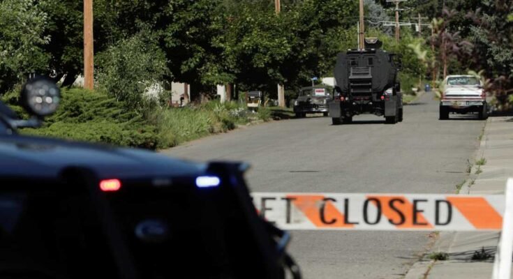 Un vehículo policial blindado se dirige a un área donde varios bomberos fueron atacados cuando respondieron a un incendio en la región de la montaña de Canfield en las afueras de Alene, Idaho el domingo.
