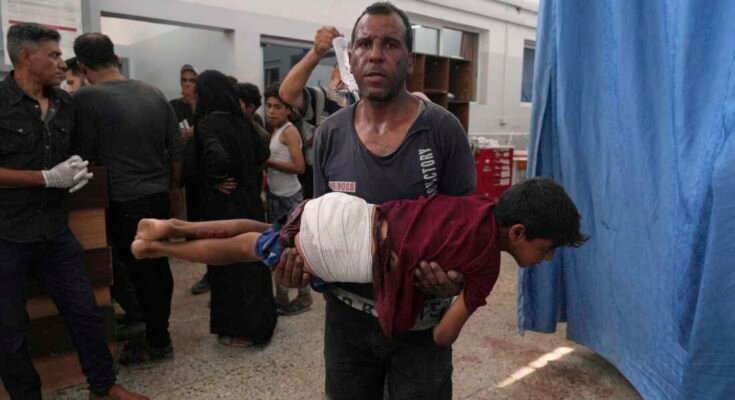 Un hombre usa un niño, herido en una huelga israelí, después de ser tratado en el Hospital Shifa, la ciudad de Gaza el lunes.