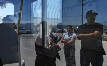 La gente espera afuera de Glass House Farms, un día después de una redada de inmigración en el establecimiento, el viernes 11 de julio de 2025, en Camallo, California.