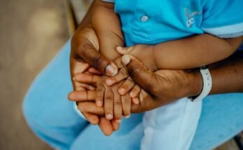 Mano de la madre africana y cerrada de la mano del niño africano